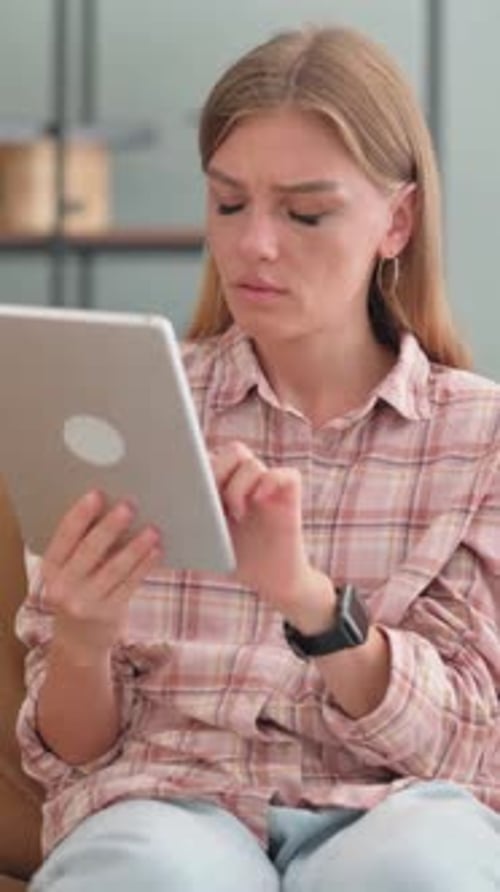 Distressed Young Woman Using Tablet at Home