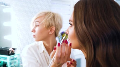 Makeup Artist Applying Lip Color on Woman