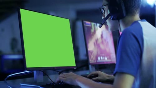 Professional Boy Gamer Plays in Video Game on Green Screen Display. He Plays on a eSports Tourname