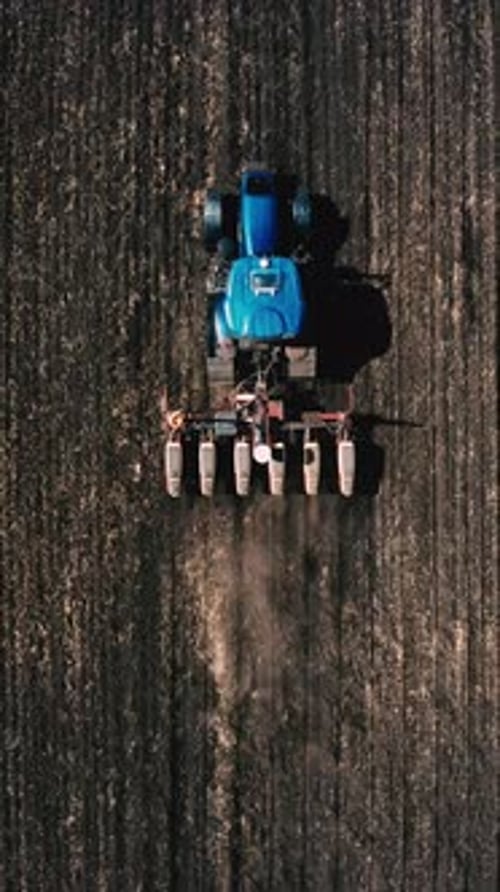 Top View Of A Tractor Working On Cultivated Land