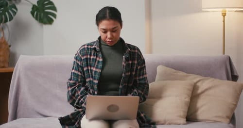 Young Woman Uses Laptop and Stretches Neck