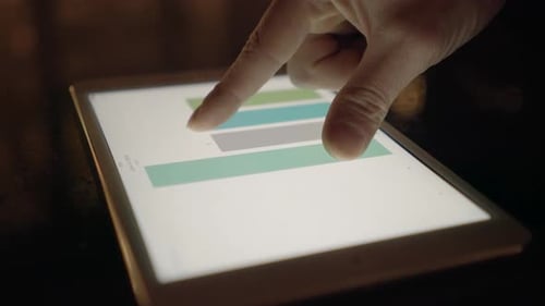 Hand Interacts with Data Charts on Tablet