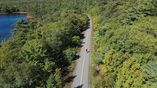 Unrecognizable Male Runner Jogging Through City Park Aerial Drone Footage
