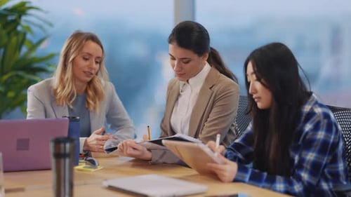 Three Attractive Multiethnic Women Collaborating in Business Office Managing Corporate Contract