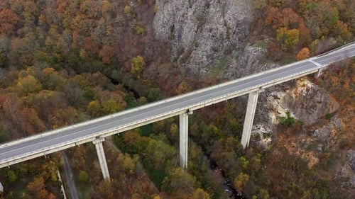 Aerial view of big viaduct of highway over the river in the mountain at autumn