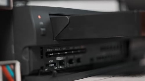 Hand Inserts VHS Tape into Retro VCR Player