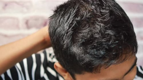 Adult Applies Hair Product to Short Styled Hair