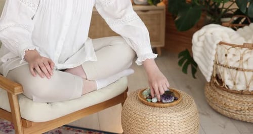 Woman Meditating with Crystals in Light and Airy Home