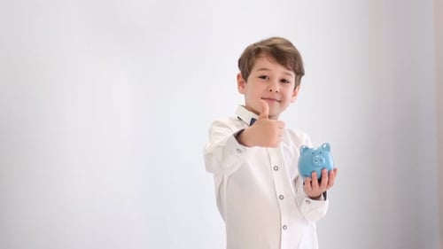 Cute Little Boy Holding a Piggy Bank and Showing Thumbs Up Concept of Successful Investment
