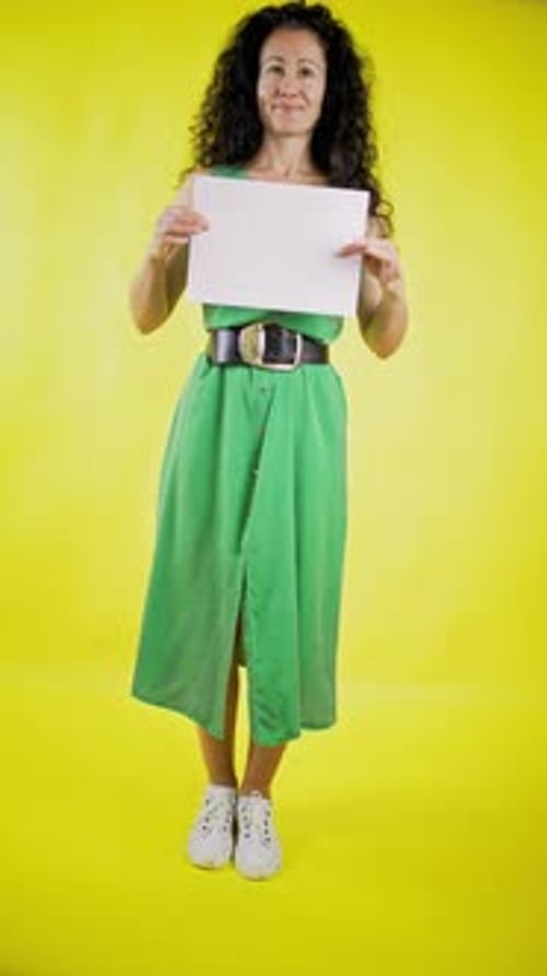 Woman Holding Blank Sign in Front of Yellow Background