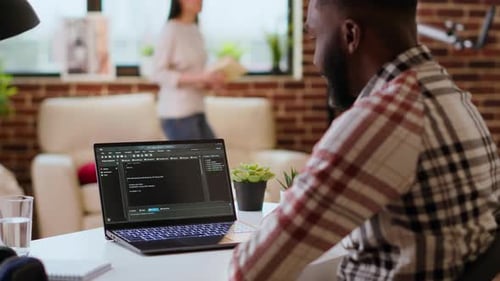Man Coding at Home on Laptop Computer