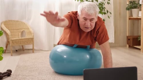 Mature Senior Man Doing Fitness Exercises Gymnastics at Home Online Lesson with Laptop Pc Talking
