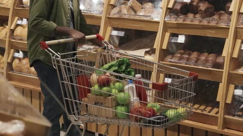 Customer With Trolley Buying Bread in Supermarket