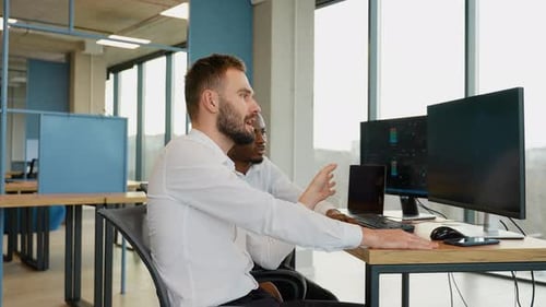 Zwei schockierte gestresste Geschäftsleute sitzen und halten Kopf an Händen am Arbeitsplatz im Büro