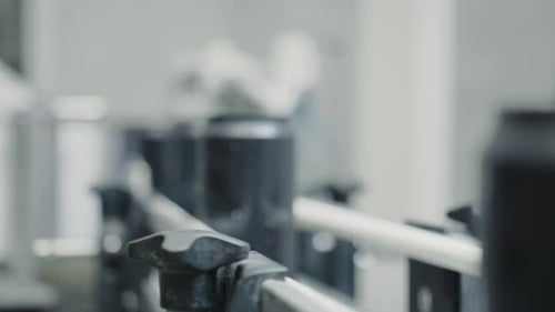 Black Cans Moving on Conveyor Belt in Factory