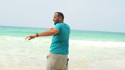 Young man warming up on tropical beach in super slow motion