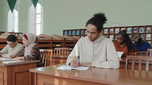 Young Black Student Making Notes During Lecture