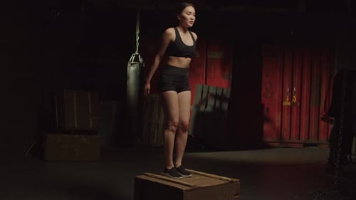 Active Motivated Sporty Fit Asian Female Doing Box Jump Exercise at Gym