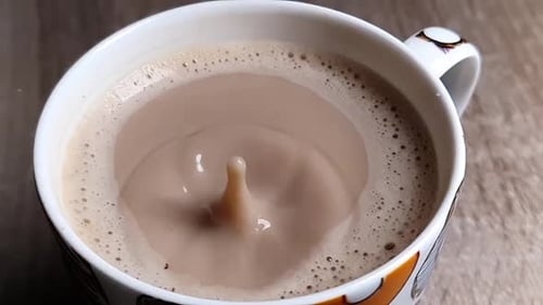 Drop Splashes Into Cup of Frothy Cappuccino