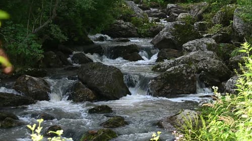 Mountain Stream Cascading Gracefully Over Rocky Terrain