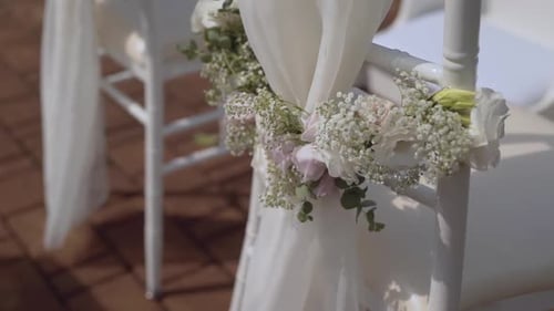 Decorated White Chairs at Wedding Ceremony