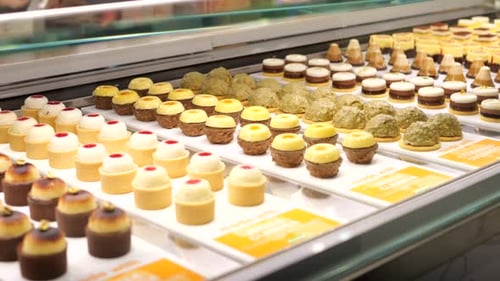Rows of gourmet sweet cream cakes presented in delicatessen patisserie SLIDE SHOT