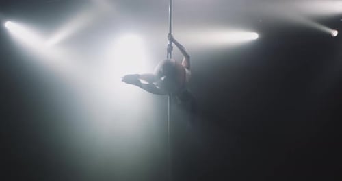 Pretty woman doing poledance in studio