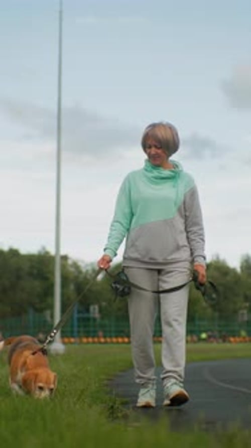 Senior Woman Strolling with Dog Older Woman Enjoying Walk with Her Pet Dog An Elderly Lady in