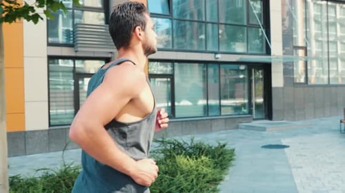 Athletic Man Jogging on City Sidewalk