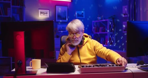 Portrait of Senior Caucasian Male Professional DJ in House in Neon Lights Music Creator Artist Works