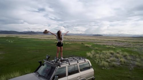 Adventurous Woman on SUV Enjoying Rural Landscape