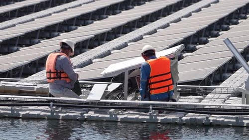 Schwimmendes Solarpanel auf dem Teich. Arbeiter arbeiten an schwimmenden Solarmodulen.