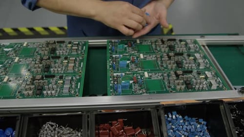 Elektronikfertigung — Draufsicht auf eine Leiterplatte, die von Hand gefertigt wird