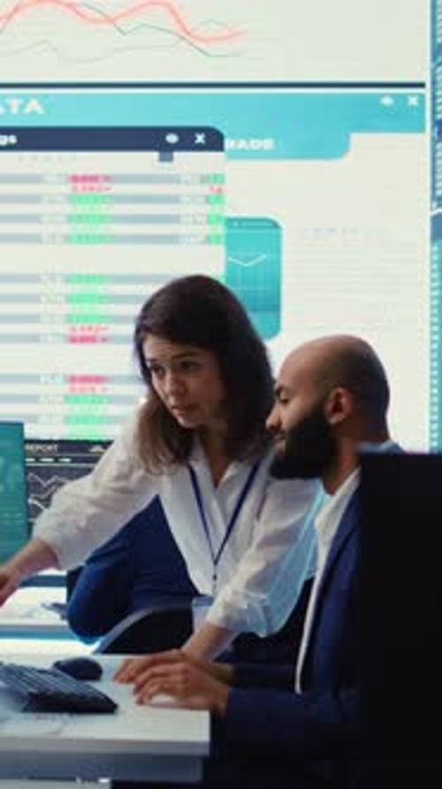 Vertical Video Teammates Examining Statistics and Infographics on Computer in Control Room