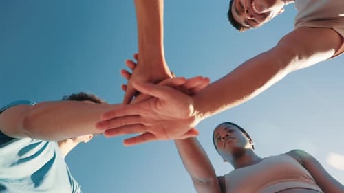 Teamwork Unity with Stacked Hands Against Blue Sky