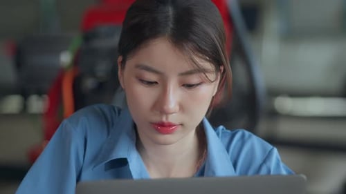 Woman Works on Laptop in Industrial Workplace