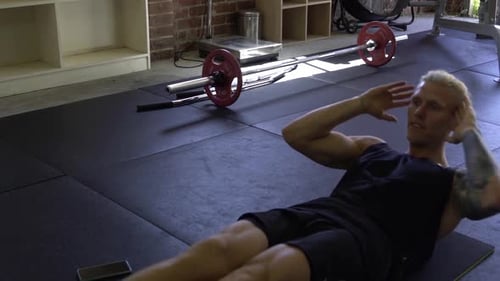 Muskulöser Mann im Heim-Fitnessstudio trainiert Bauchmuskelübungen