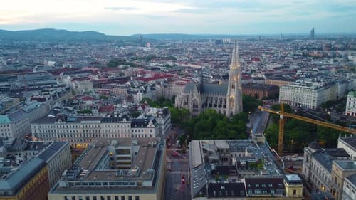 Vue aérienne panoramique en descente de l'église Votivkirche à Vienne, en Autriche, au crépuscule avec des lumières illuminées