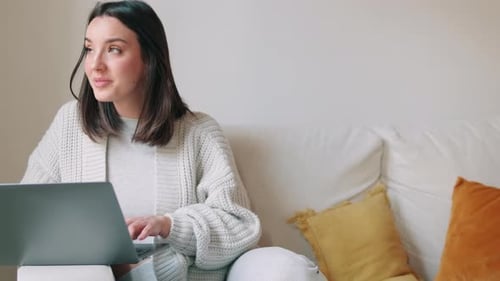 Woman Using Laptop on Couch at Home