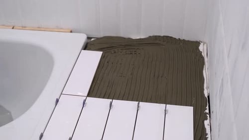 Laying White Tiles in a Bathroom Space