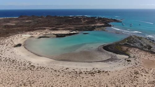 Aerial view: Turquoise water bathes the white sand beach of Lobos Island, Fuerteventura in the