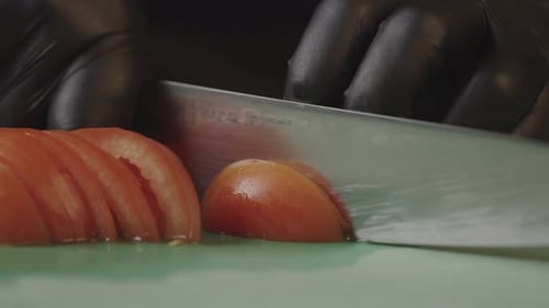 Slicing a Tomato with a Knife Close Up