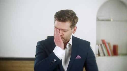 Der
attraktive junge Geschäftsmann ist überformelt und müde. Er ist erschöpft. Der Mann trägt eine blaue Sonne