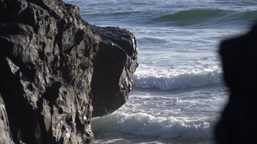 Meereswellen krachen und durchqueren die Felsen am Strand. statisch