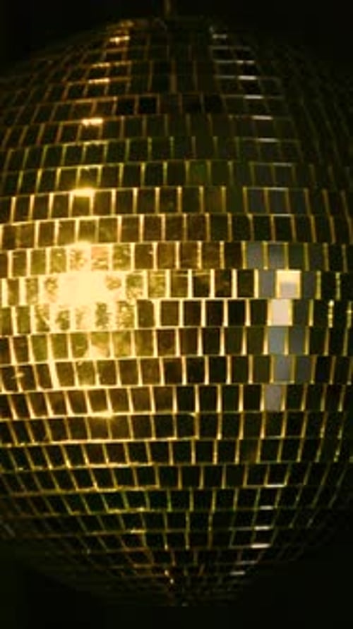 Disco ball reflecting light in a vibrant dance floor. Vertical