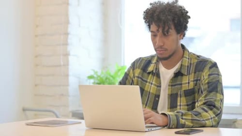Busy African Man Typing on Laptop in Office