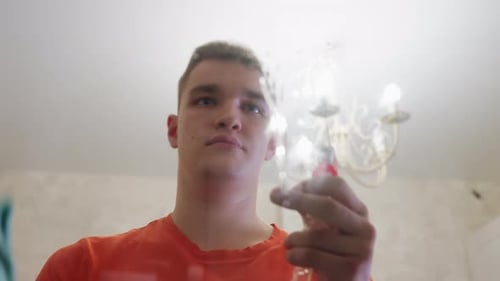 Young Man Cleaning a Glass Table with Spray