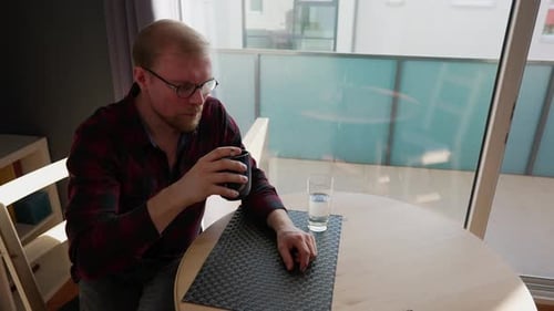 Man Drinking Coffee at Table Indoors