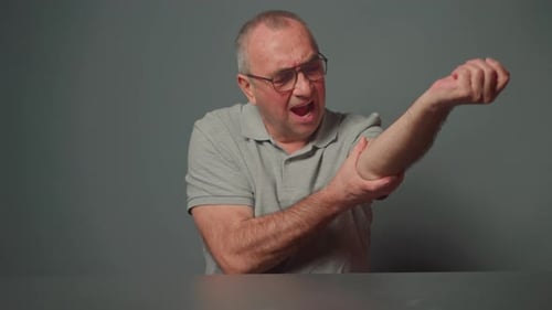 Man Rubbing Elbow Showing Joint Pain and Discomfort