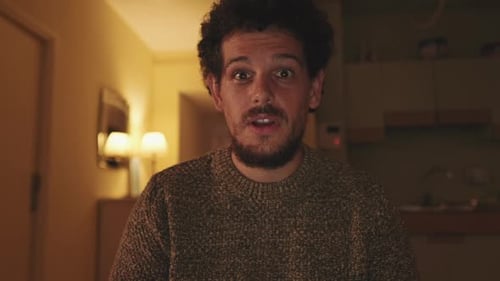 Man Talking and Gesturing in Warm-Lit Home